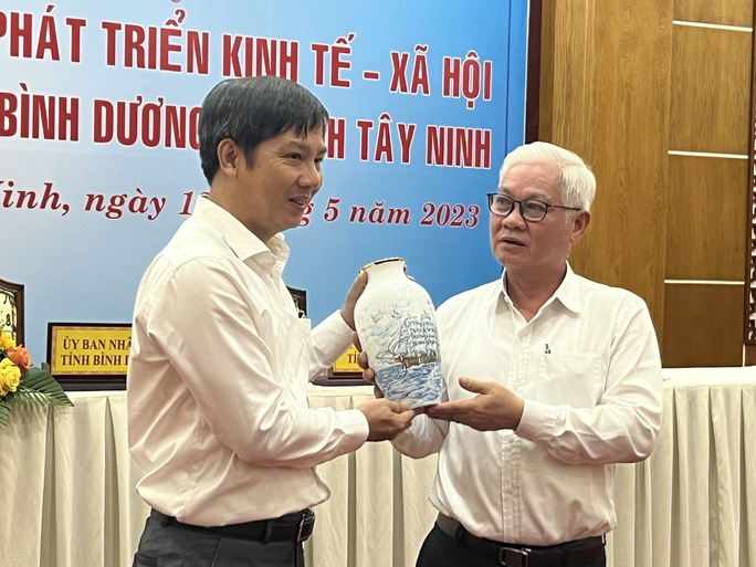 Thay mặt lãnh đạo tỉnh Tây Ninh, ông Nguyễn Thành Tâm, Bí thư Tỉnh ủy (trái) nhận món quà lưu niệm từ ông Nguyễn Văn Lợi, Bí thư Tỉnh ủy Bình Dương.